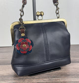 Leather flower bag charm on Navy Leather Princess Anne Kiss Lock Bag – handcrafted leather accessory.