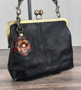 Leather flower bag charm on Black Leather Princess Anne Kiss Lock Bag – handcrafted leather accessory.