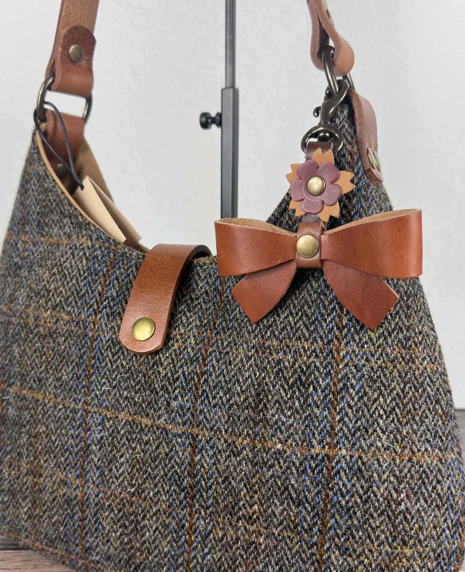 Leather bow bag charm clipped to Harris Tweed Rhode River Shoulder bag – handcrafted purse accessory cut by hand.