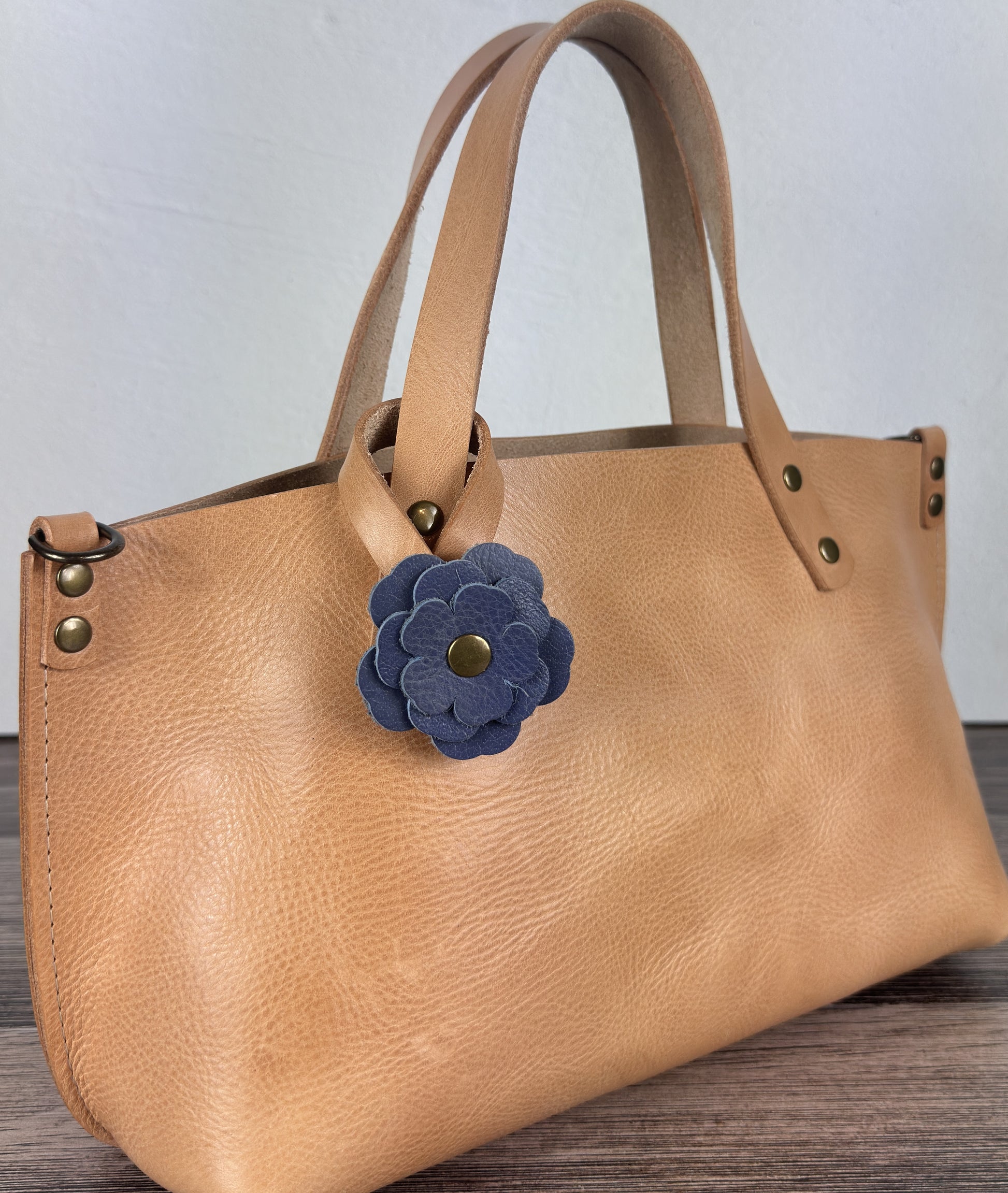 Leather flower bag charm on Leather Tote Bag – handcrafted leather accessory.