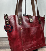 Red leather handbag with decorative leather flower charm.  