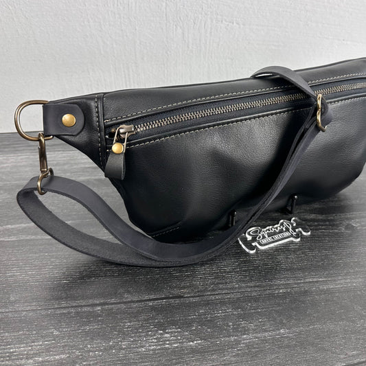 Side view of Leather Spinnaker Sling bag in Black with bronze hardware, Wickett & Craig Black English Bridle Leather Strap, and front zipper. Unisex slim crossbody sling handmade in Maryland.