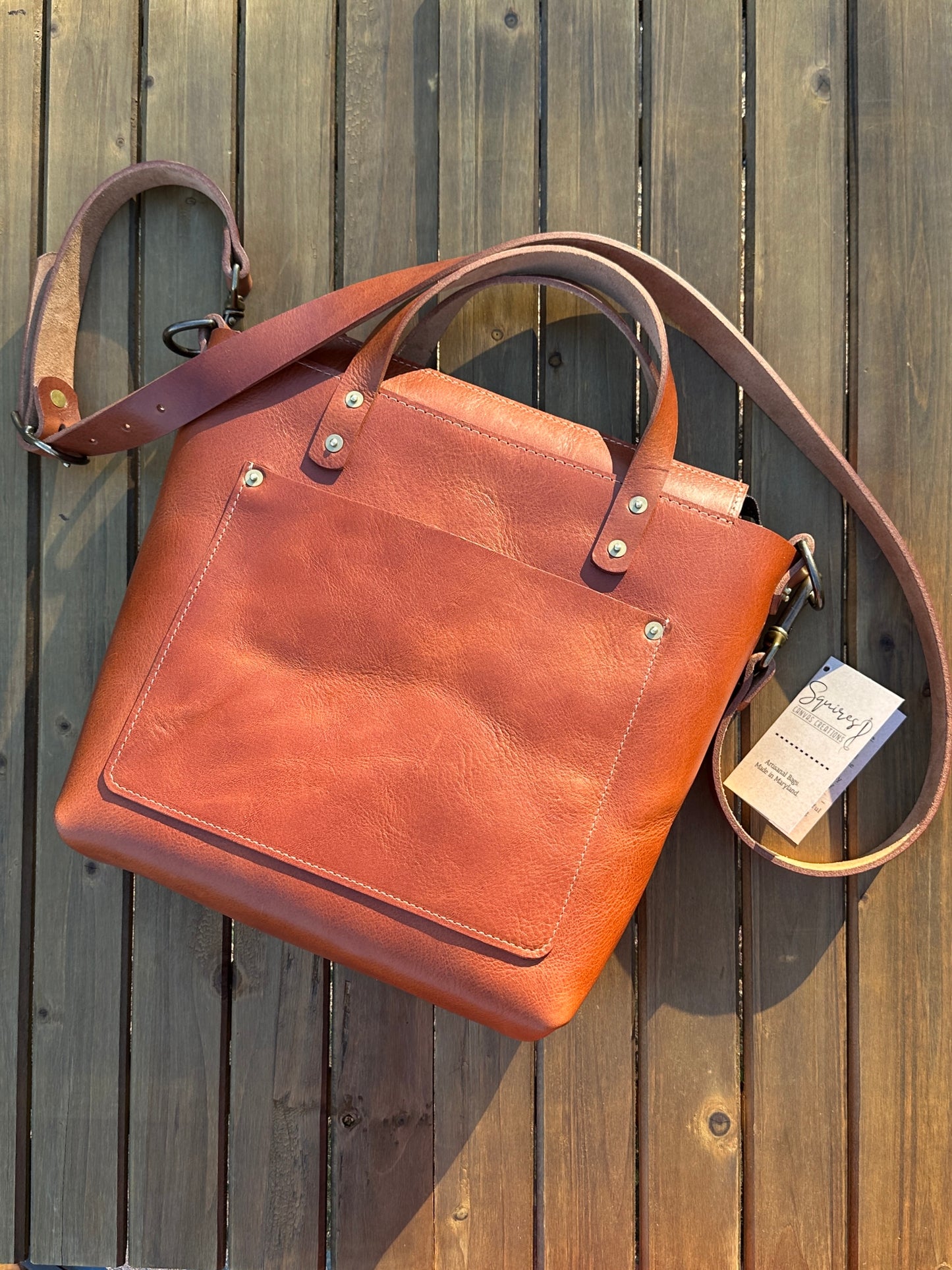 “Flat view of the Cherry West Street Crossbody bag made with vegetable-tanned leather.