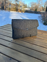 Front profile of the Skye Fold clutch in a sophisticated Black and Charcoal Herringbone Harris Tweed®. An understated, everyday elegance that transitions perfectly into an evening-ready look.