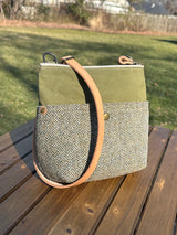 Handcrafted Barra crossbody bag featuring Green and Beige Barleycorn Harris Tweed and olive Halley Stevensons waxed canvas. Includes a natural leather adjustable strap and brass hardware for a rugged, refined aesthetic.