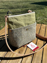 Artisan-made vertical Barra Crossbody bag with two exterior magnetic slip pockets. The Barleycorn Harris Tweed and olive green waxed canvas create a sophisticated, heritage-inspired look for everyday carry.