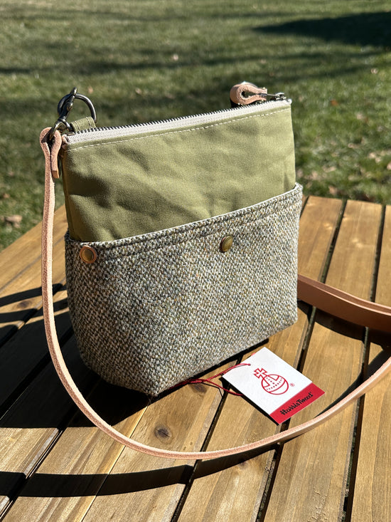 Artisan-made vertical Barra Crossbody bag with two exterior magnetic slip pockets. The Barleycorn Harris Tweed and olive green waxed canvas create a sophisticated, heritage-inspired look for everyday carry.