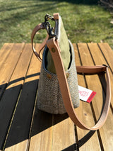 Side view of the Barra Crossbody bag showcasing top-mounted D-ring connectors and a natural tan leather strap. Designed for superior hang and durability, this hybrid canvas and tweed bag is an all-weather essential.