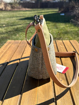 Side view of the Barra Crossbody bag showcasing top-mounted D-ring connectors and a natural tan leather strap. Designed for superior hang and durability, this hybrid canvas and tweed bag is an all-weather essential.